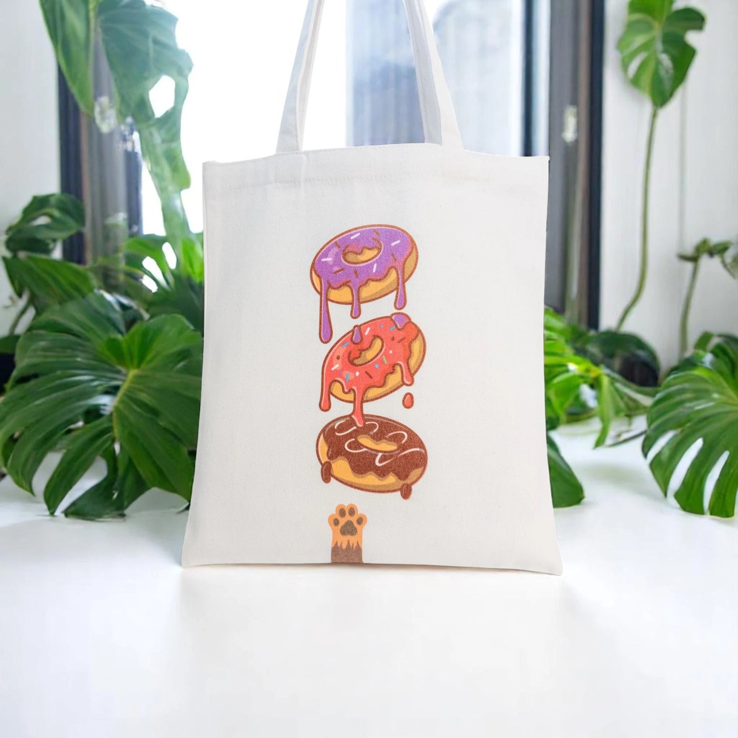 Tote maišelis iš priekio ant balto stalviršio tarp augalų